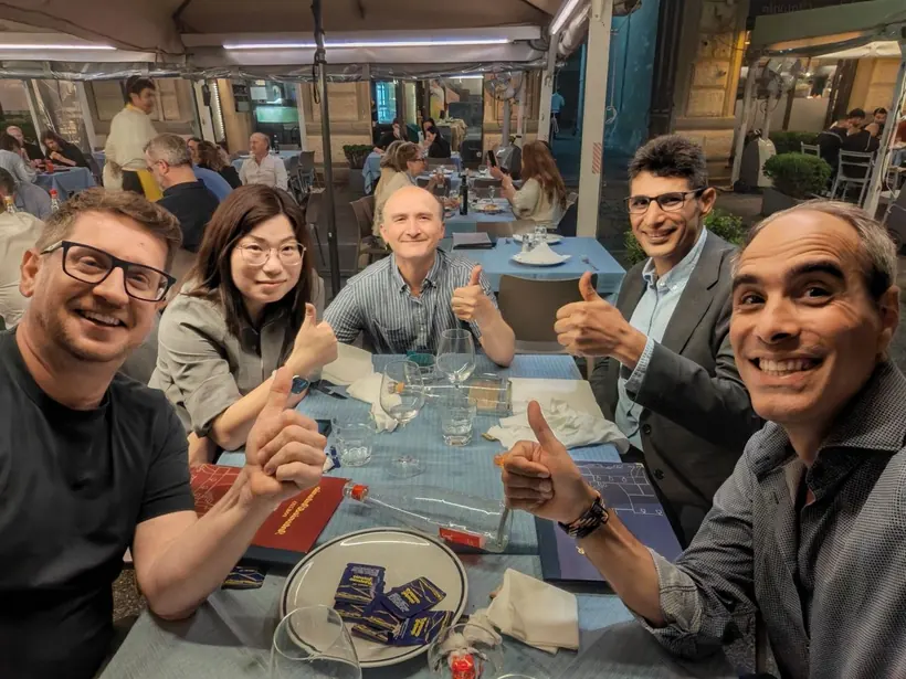 Researchers together over dinner following conference sessions · 2026